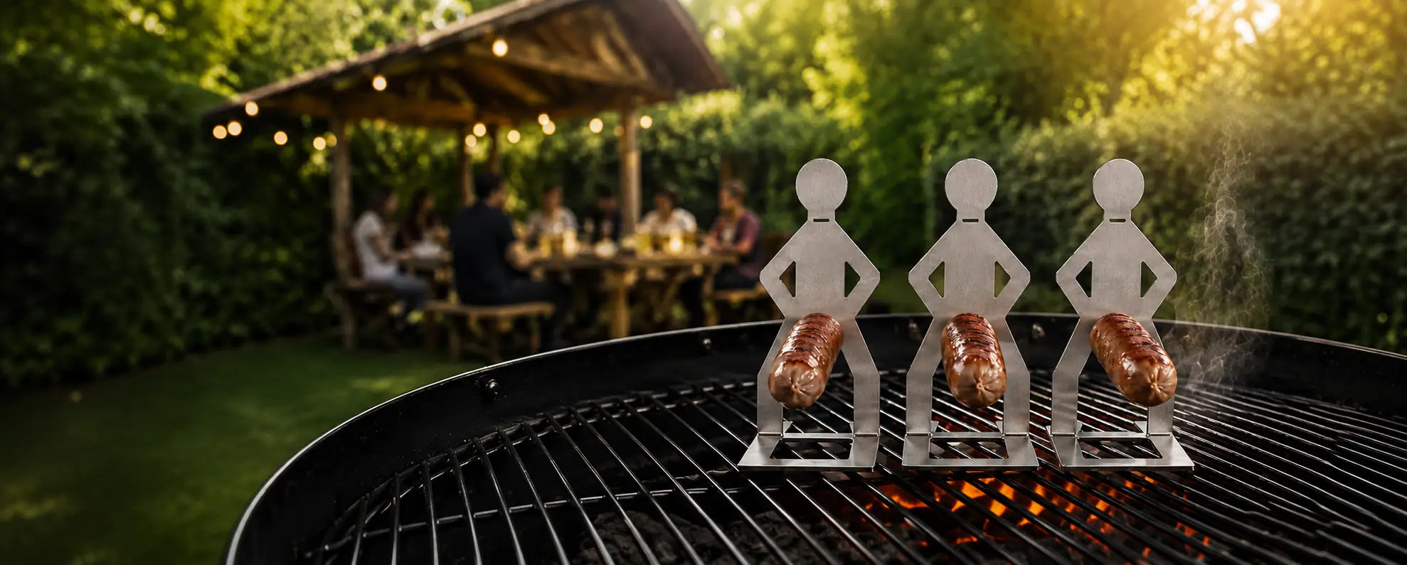 MeatRider Bratwursthalter 3er-Set aus Edelstahl mit gegrillten Bratwürsten auf dem Grill als praktisches BBQ-Zubehör für Grillfans.
